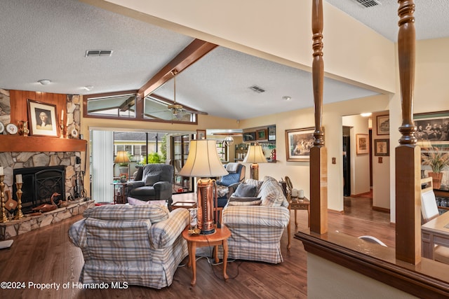 living room with lofted ceiling with beams, wood-type flooring, a fireplace, a textured ceiling, and ceiling fan