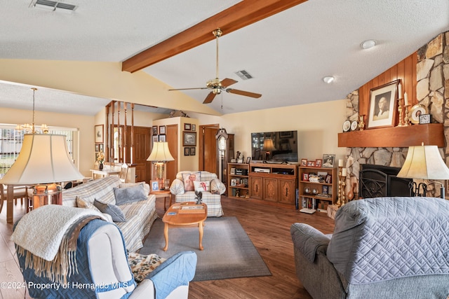 living room featuring ceiling fan, a textured ceiling, hardwood / wood-style floors, a fireplace, and lofted ceiling with beams