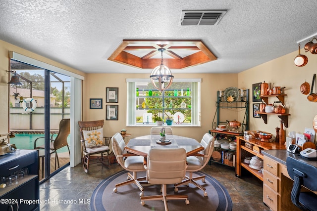 dining space with a textured ceiling and a notable chandelier