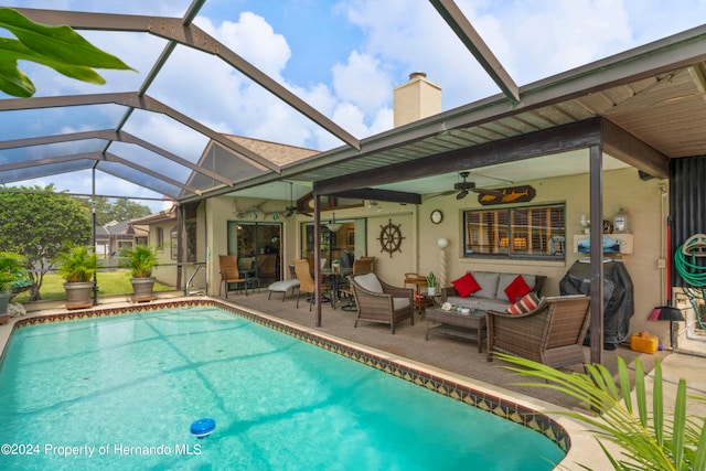 view of pool with a lanai, ceiling fan, a patio, and an outdoor living space