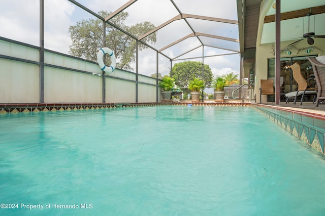 view of pool with ceiling fan and glass enclosure