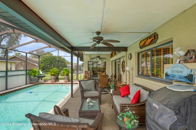 view of swimming pool featuring an outdoor hangout area, a patio area, glass enclosure, and ceiling fan