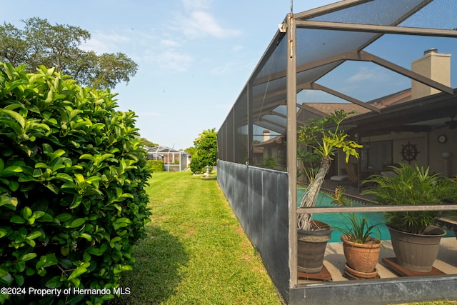 view of yard with a swimming pool and glass enclosure