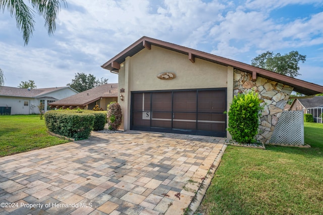 single story home featuring a garage and a front yard