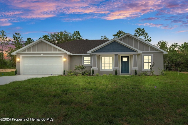 view of front of house with a garage and a yard