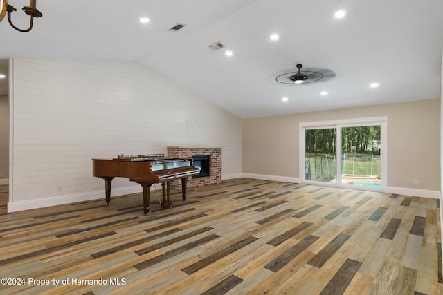 interior space featuring a fireplace, lofted ceiling, hardwood / wood-style flooring, and ceiling fan