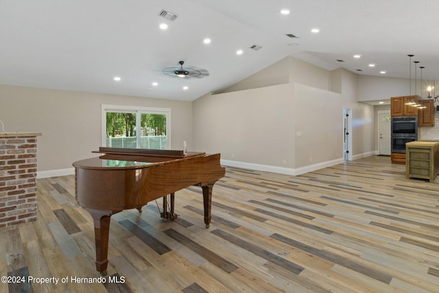 recreation room with light wood-type flooring, ceiling fan, and high vaulted ceiling