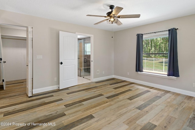 unfurnished bedroom with light hardwood / wood-style floors, ceiling fan, and a closet