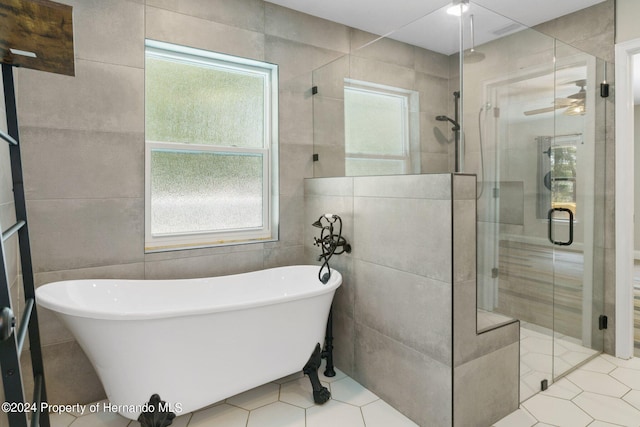 bathroom featuring a wealth of natural light, independent shower and bath, tile walls, and tile patterned flooring