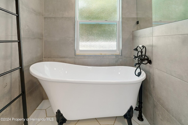 bathroom with tile walls, tile patterned flooring, and a bathing tub