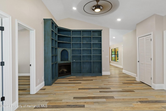 unfurnished living room featuring light hardwood / wood-style floors, lofted ceiling, and ceiling fan