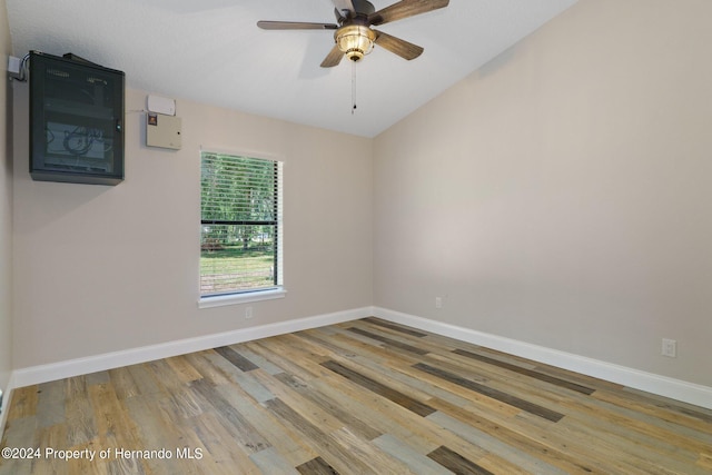 spare room featuring lofted ceiling, ceiling fan, and light hardwood / wood-style flooring