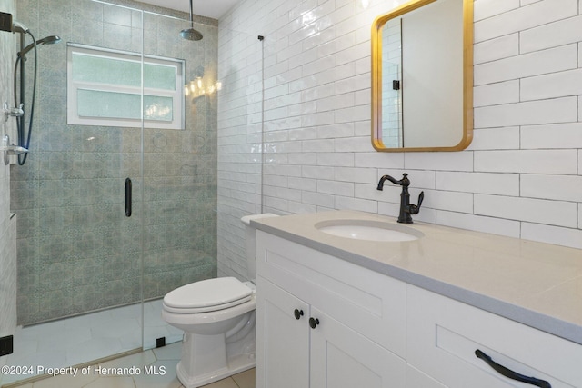 bathroom with tile patterned floors, a shower with door, tile walls, vanity, and backsplash