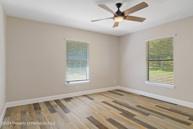 unfurnished room featuring light wood-type flooring, ceiling fan, and plenty of natural light