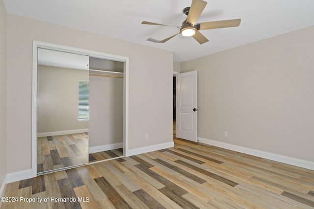 unfurnished bedroom featuring a closet, light wood-type flooring, and ceiling fan