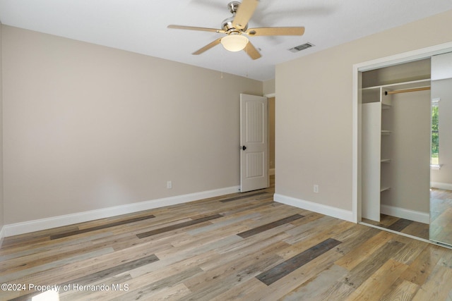 unfurnished bedroom featuring ceiling fan, a closet, and light hardwood / wood-style flooring