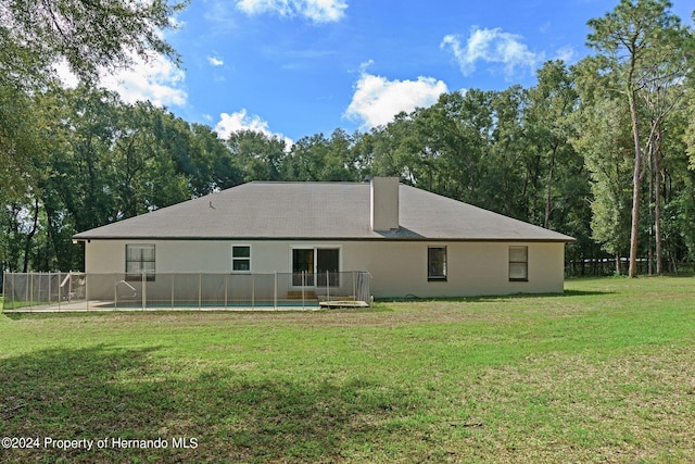 back of house featuring a lawn