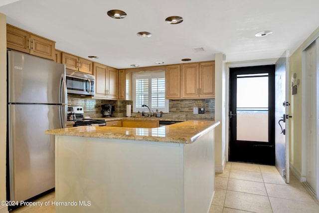 kitchen featuring stainless steel appliances, light stone counters, light tile patterned flooring, and tasteful backsplash