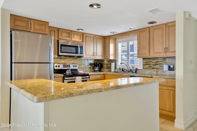 kitchen featuring light tile patterned flooring, sink, light stone counters, appliances with stainless steel finishes, and backsplash