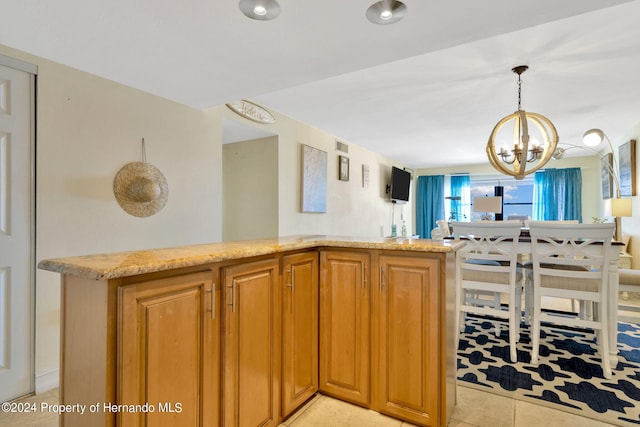 kitchen featuring pendant lighting, light tile patterned floors, an inviting chandelier, and light stone counters