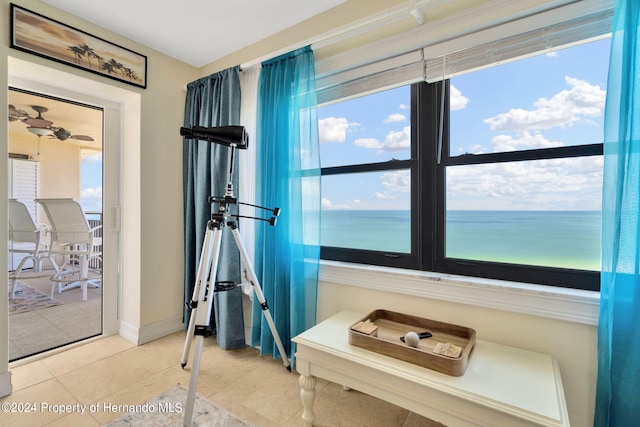 interior space featuring plenty of natural light, tile patterned floors, and a water view