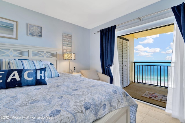 tiled bedroom featuring a water view