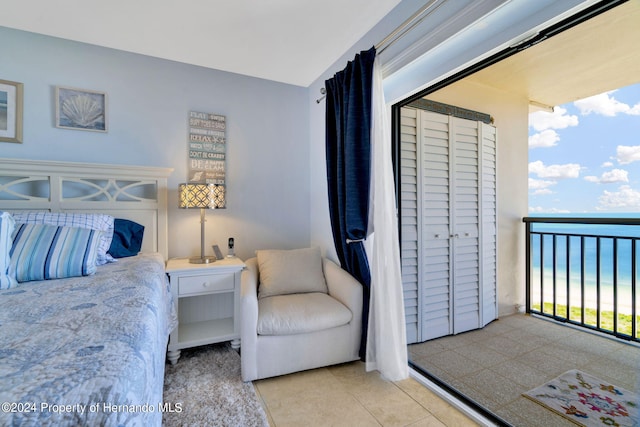 bedroom featuring a water view and multiple windows