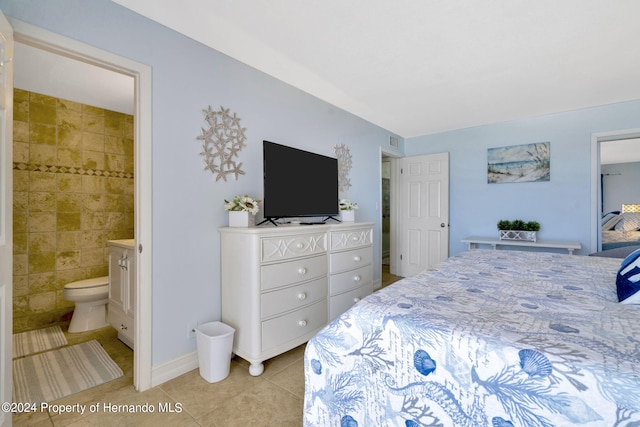 bedroom with tile walls, ensuite bath, and light tile patterned floors