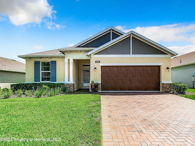 view of front of property featuring a garage and a front lawn