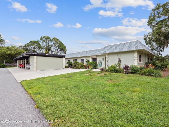 ranch-style house featuring a front lawn, a garage, and a carport