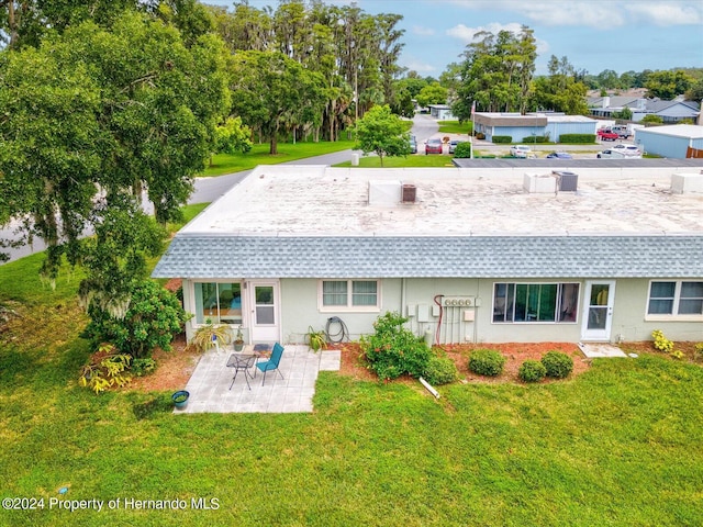 back of property with a patio and a yard