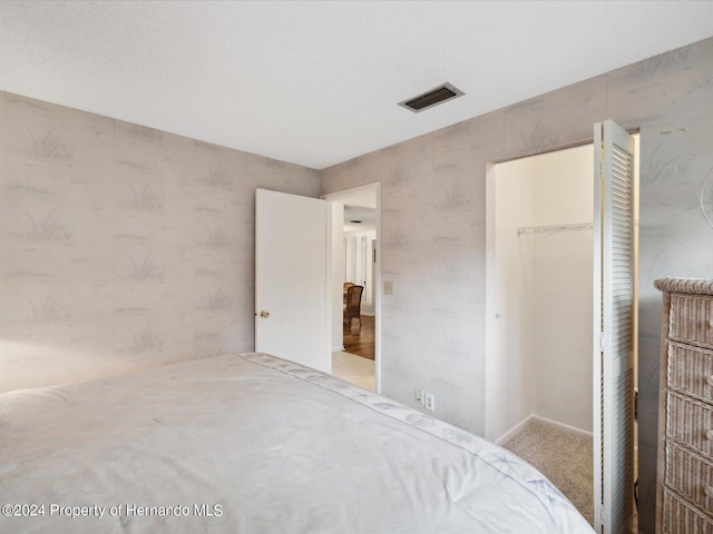 bedroom with carpet flooring, a walk in closet, and a closet