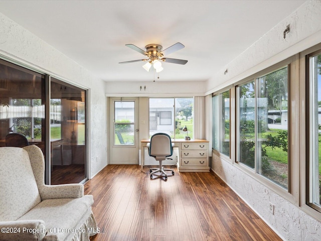 home office with dark hardwood / wood-style flooring and ceiling fan