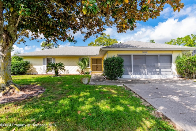 single story home with a garage and a front lawn