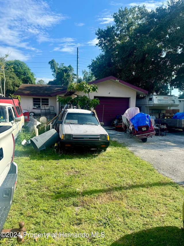 single story home with a garage and a front lawn