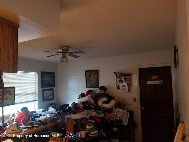 interior space with ceiling fan and a textured ceiling