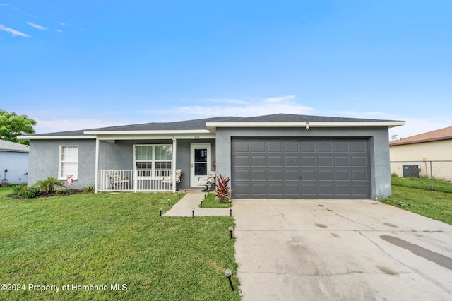 single story home with a garage, a front lawn, and covered porch