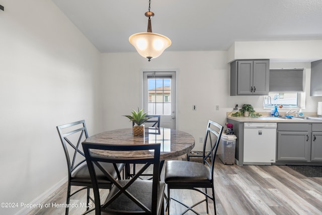 dining space featuring sink, a healthy amount of sunlight, and light hardwood / wood-style floors