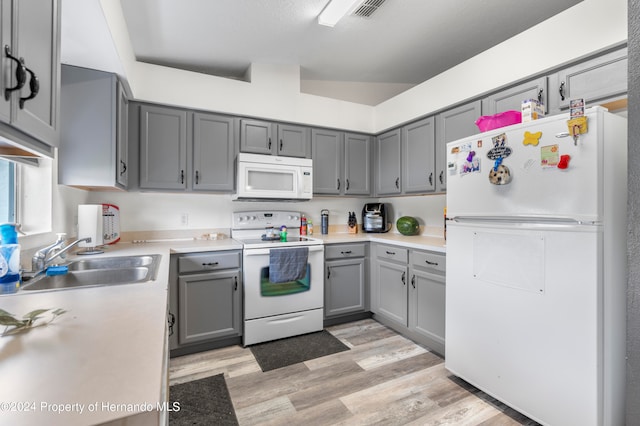 kitchen featuring white appliances, sink, light hardwood / wood-style flooring, and gray cabinets