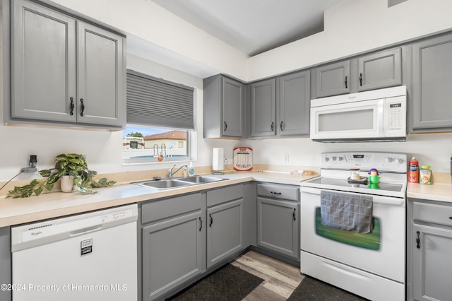 kitchen featuring sink, white appliances, and gray cabinetry