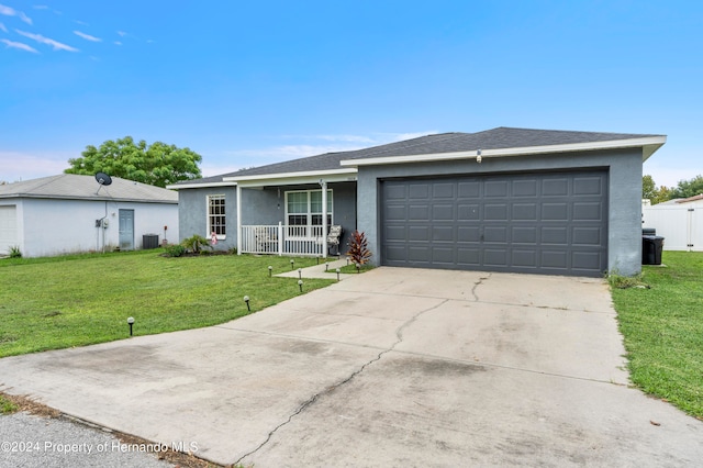 single story home featuring a garage, a porch, a front yard, and central AC unit