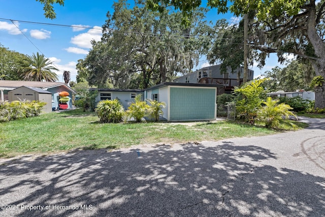 5369 Tuscawilla Dr, Weeki Wachee, FL 34607 - view of front of house with a shed and a front yard