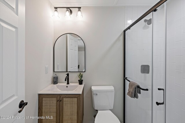 bathroom with walk in shower, vanity, and toilet