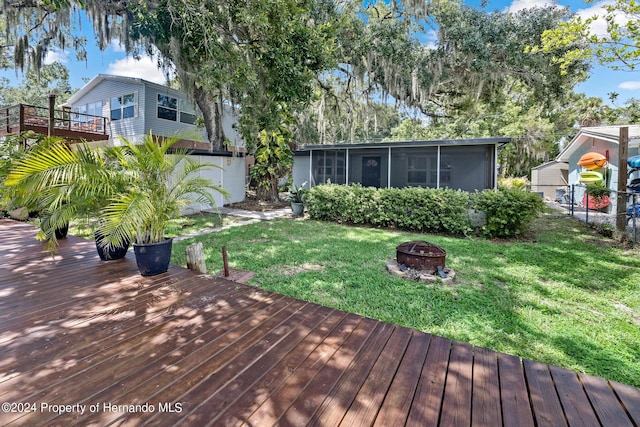 5369 Tuscawilla Dr, Weeki Wachee, FL 34607 - wooden terrace with an outdoor fire pit and a sunroom