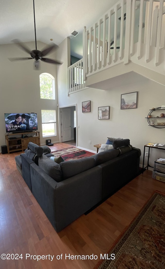 living room with ceiling fan, hardwood / wood-style floors, and high vaulted ceiling