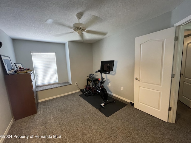 exercise room with dark colored carpet, a textured ceiling, and ceiling fan