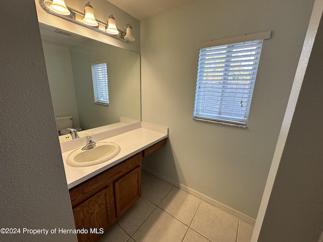 bathroom with tile patterned flooring, vanity, and toilet