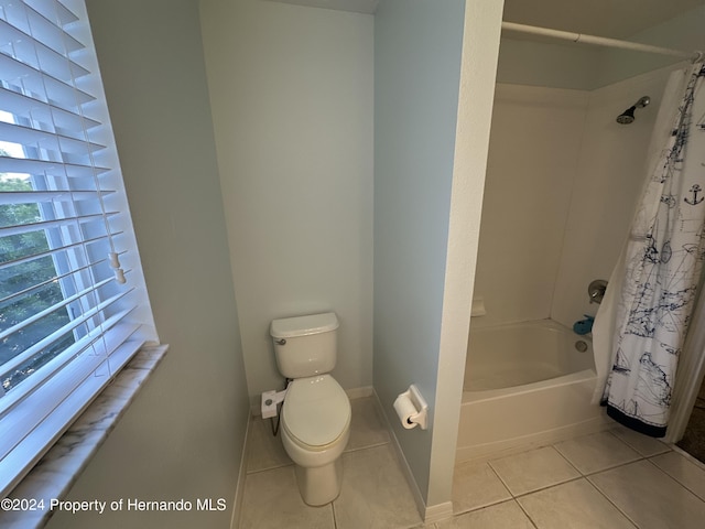 bathroom featuring shower / bath combination with curtain, tile patterned floors, and toilet