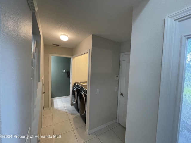 laundry room featuring light tile patterned flooring, washer and dryer, and a textured ceiling