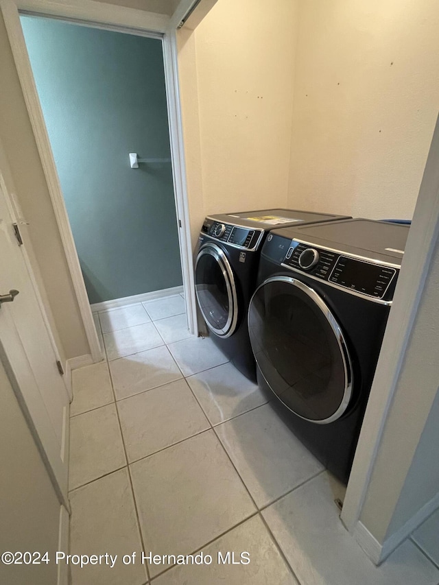 washroom with light tile patterned floors and washer and dryer